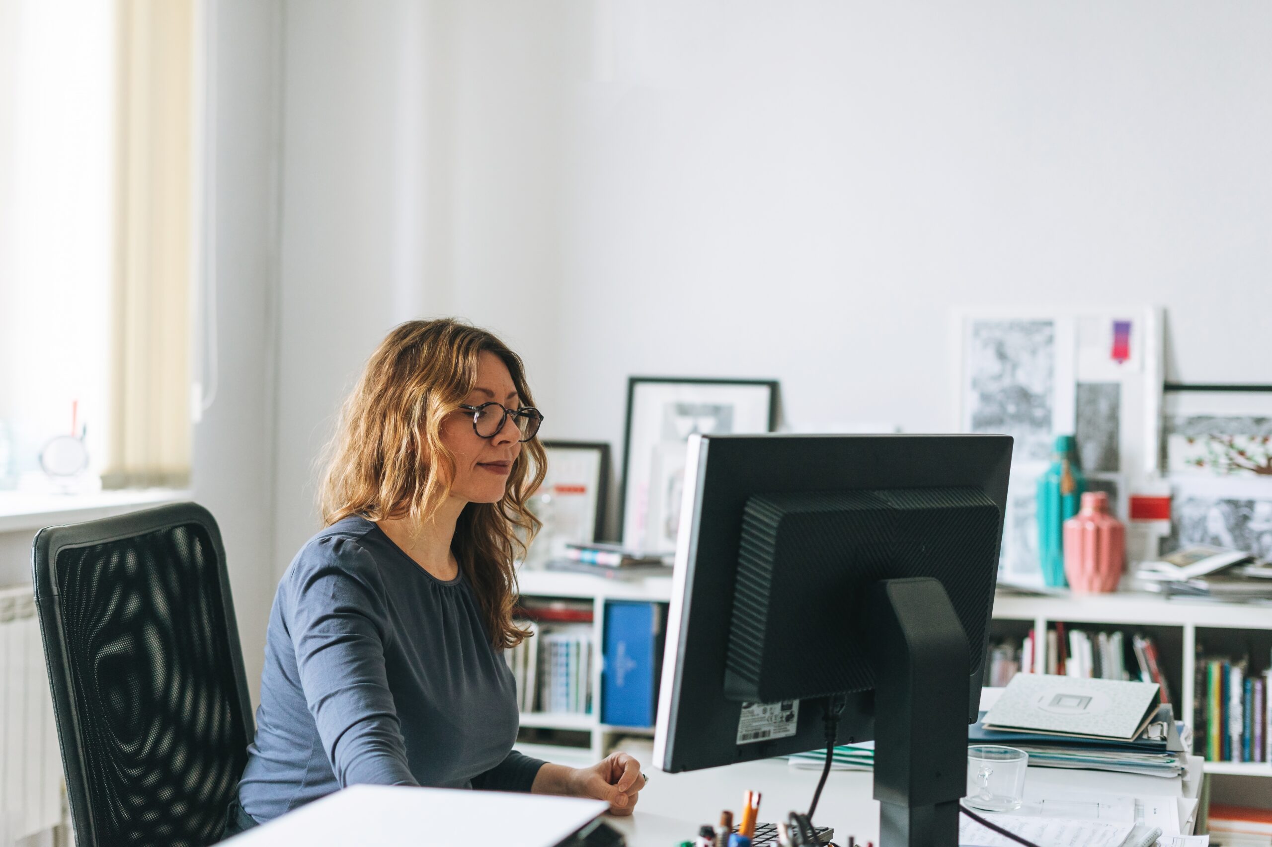 Une femme devant son bureau pour une prise de contact sur la retraite